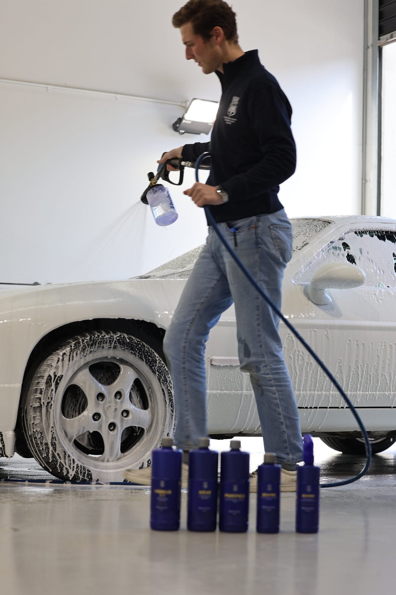 Applying alkaline snow foam pre-wash to a dry Porsche with a foam cannon at Alpha Details Melbourne