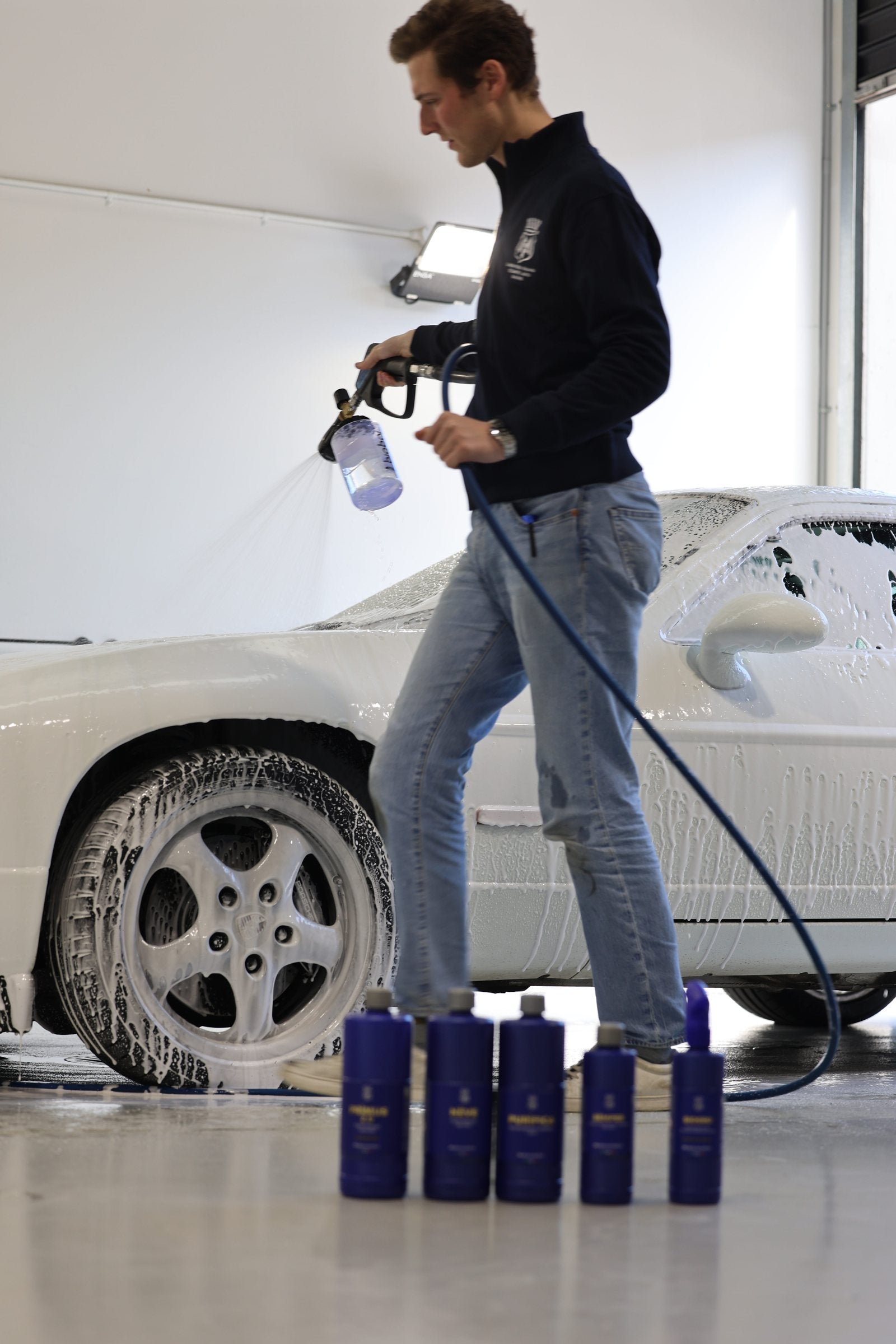 Applying alkaline snow foam pre-wash to a dry Porsche with a foam cannon at Alpha Details Melbourne