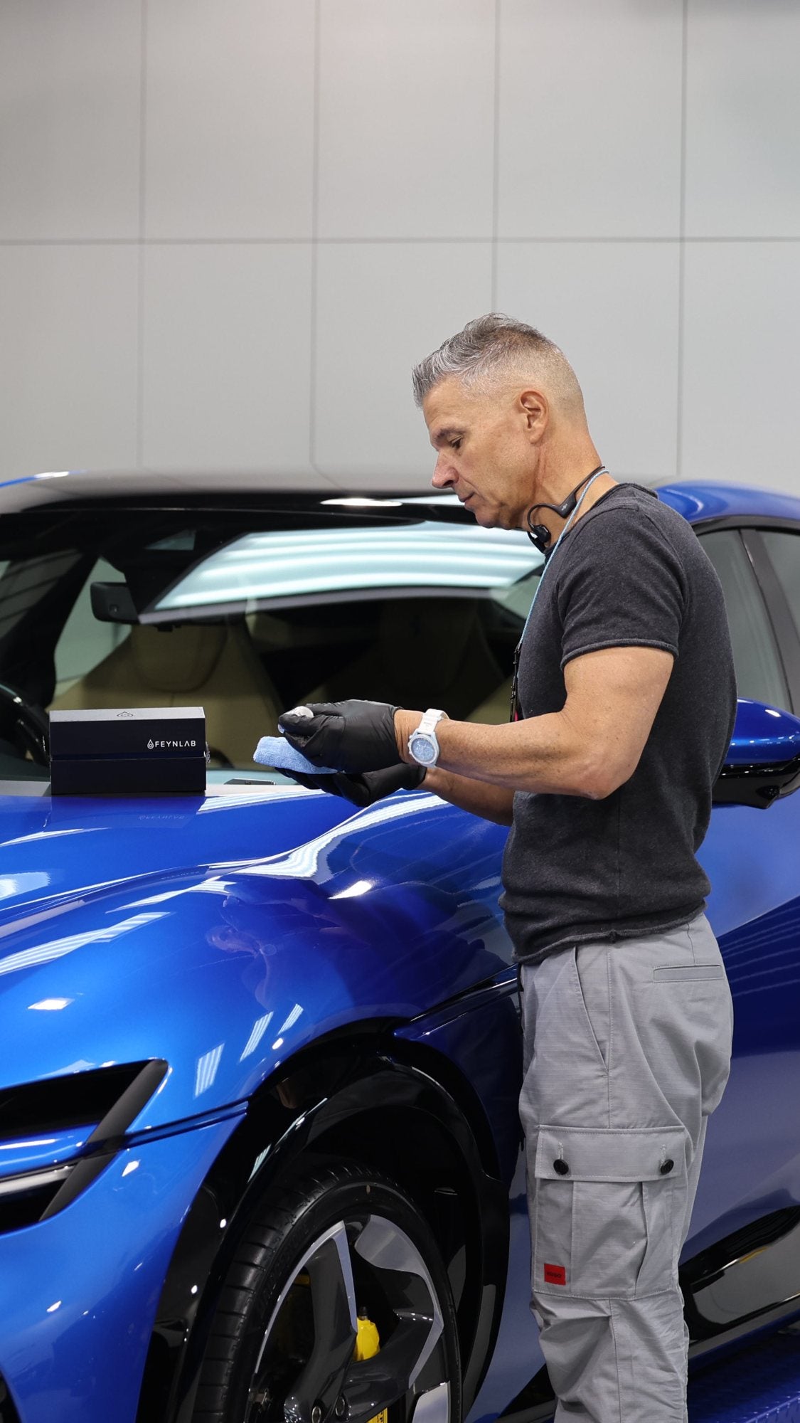 Paolo from Alpha Details detailing a blue car in the studio