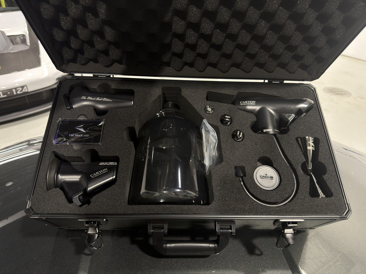 Carton The Black Suit Edition kit open in its aluminium flight case at the Alpha Details studio, showing the serial-numbered sprayer, 2.5L black bottle and accessories