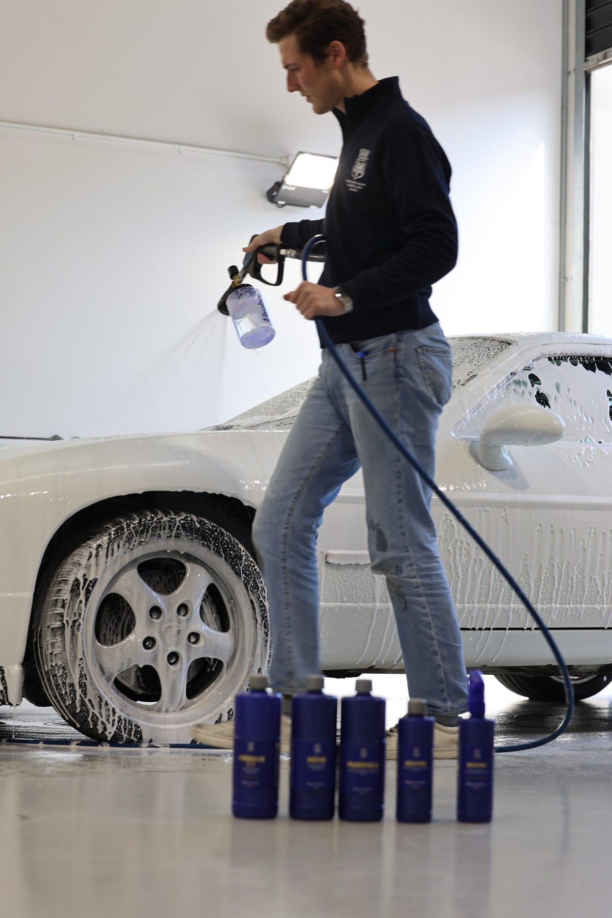 Foam being sprayed onto a wheel with a pressure washer at Alpha Details
