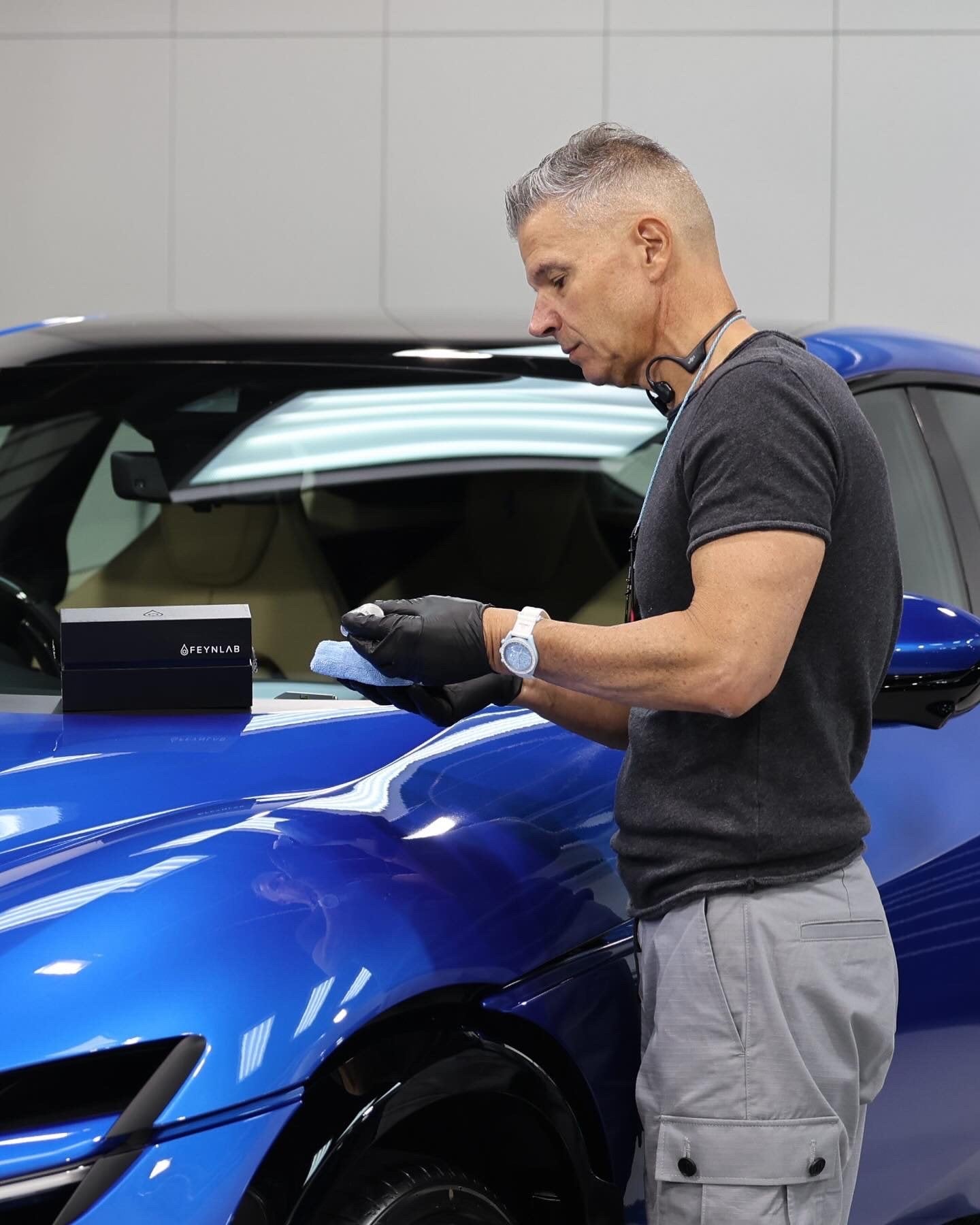 Paolo from Alpha Details polishing a blue sports car in the Melbourne studio