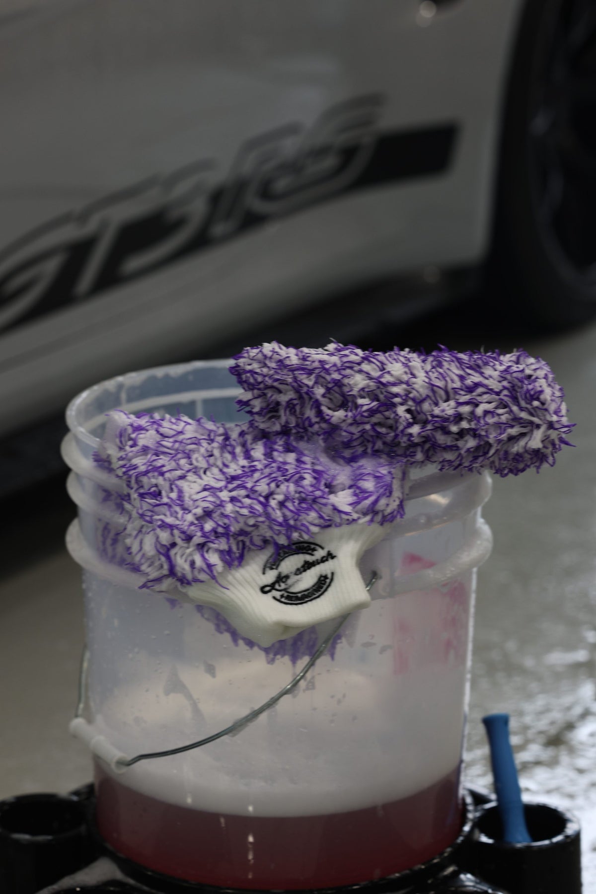 Aquatouch BOSS wash mitt loaded with shampoo, close-up of the purple plush pile and white Aquatouch cuff