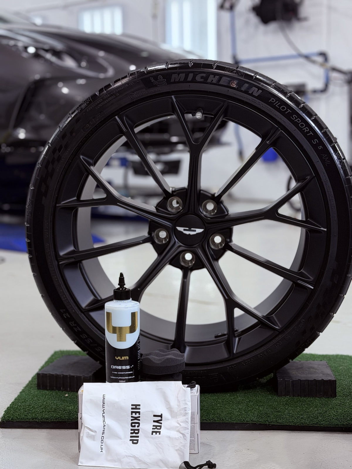 Yum Cars Dress V2 tyre dressing and Tyre HexGrip applicator in front of a satin black wheel at the Alpha Details studio